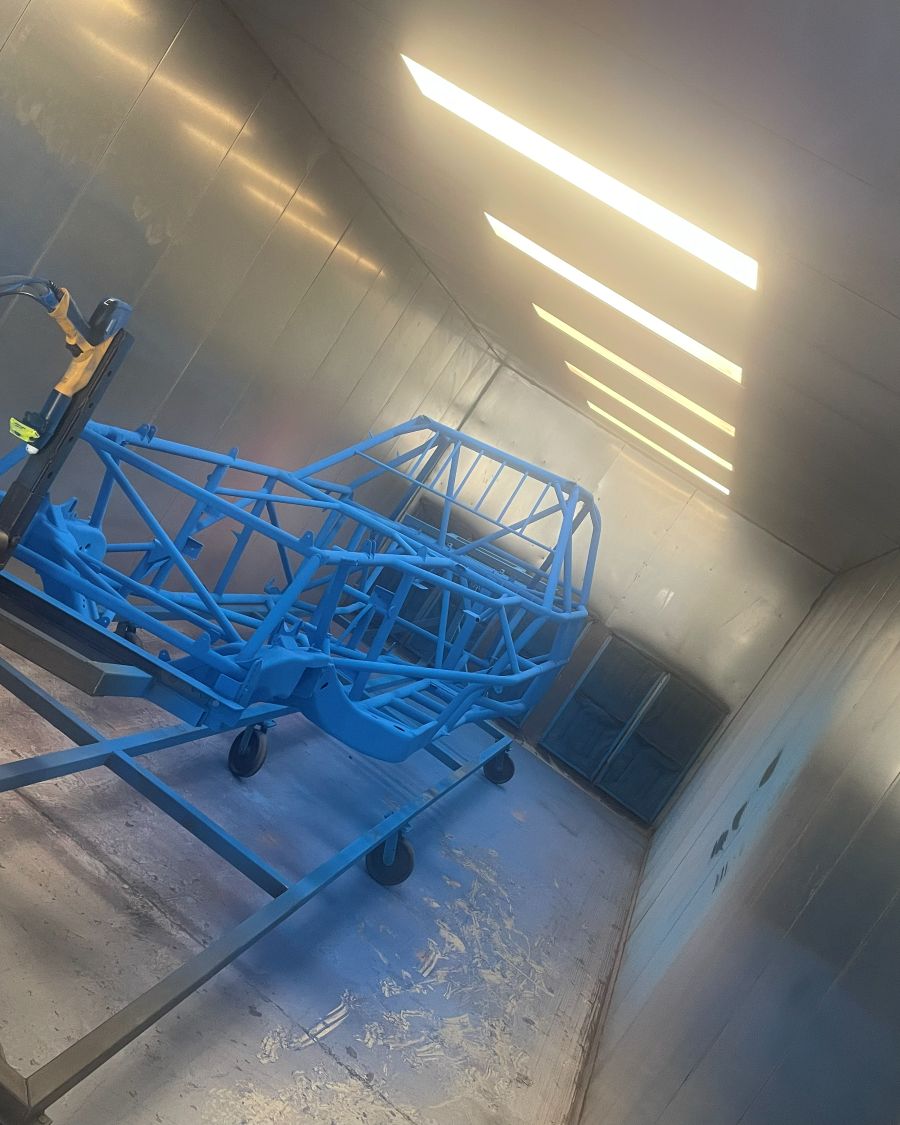 Chassis being coated in blue in the booth